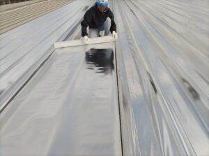 折板屋根への遮熱シート貼付作業|サーモバリア施工中