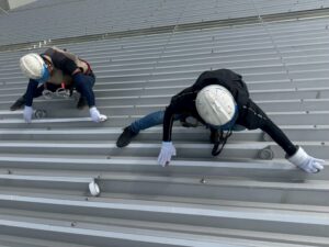 折板屋根にサーモバリア遮熱シートを施工した遮熱工事の様子と建物外観（工場・倉庫の暑さ対策）