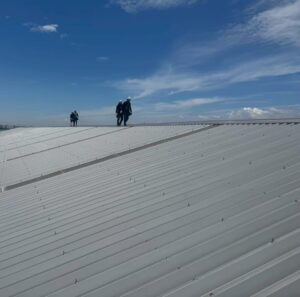 折板屋根にサーモバリア遮熱シートを施工した遮熱工事の様子と建物外観（工場・倉庫の暑さ対策）