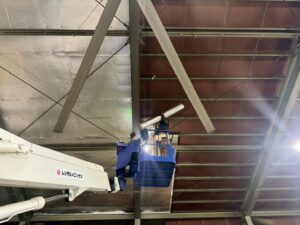 株式会社シンテック様工場内で高所作業車を使用し、屋根下にサーモバリアSを施工している作業風景。