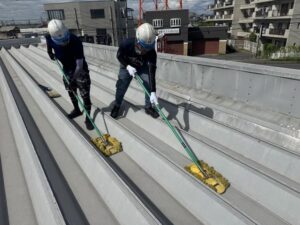 安楽亭 遮熱シート施工中｜モップを使用したシート圧着作業状況