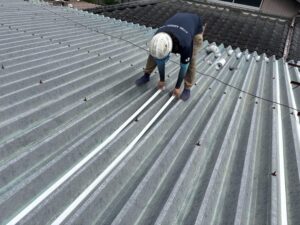 遮熱シート施工前に屋根の固定部へ専用テープを施工している様子