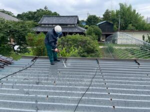 遮熱シート施工前に折板屋根を洗浄している作業中の様子